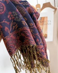 Close-up of elegant long scarf with paisley floral patterns and fringe tassels