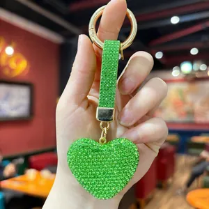 Detailed view of a glittering green rhinestone heart keychain with matching strap