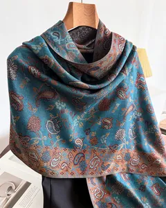 Close-up view showing the intricate teal paisley pattern on a warm winter cashmere-like shawl