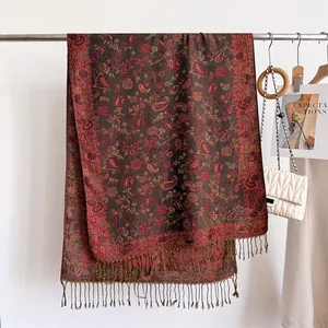Detailed view of the intricate paisley pattern and tassels on the brown shawl