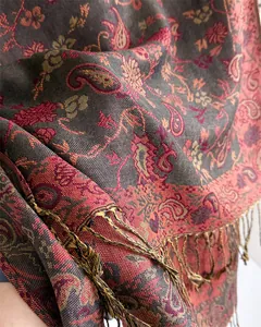 Detail view of the elegant paisley pattern and tassel fringe on a warm winter shawl