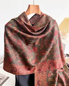 Detailed macro view showing the intricate paisley floral pattern and texture of this warm shawl.