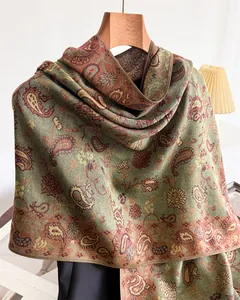 Detailed view of elegant green and brown paisley pattern on warm faux cashmere winter shawl.