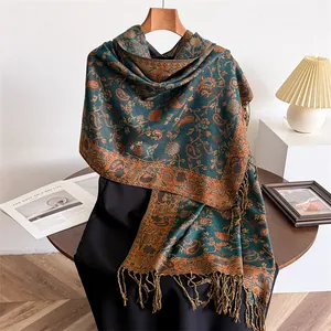 Detailed view of an elegant paisley patterned winter shawl with long fringe tassels.