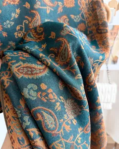 Close-up of elegant paisley pattern on warm teal and orange cashmere-like shawl