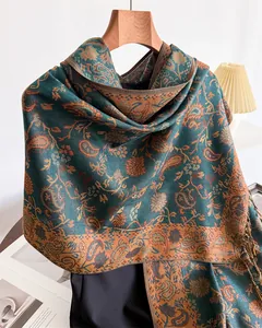 Detail of teal and orange paisley faux cashmere shawl with elegant fringe tassels