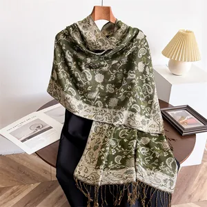 Detailed macro view of elegant green paisley scarf with soft fringe tassels