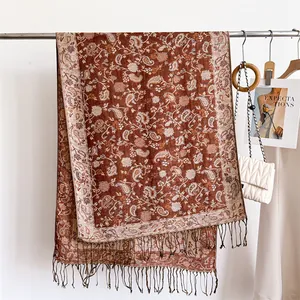 Close-up of elegant paisley pattern and long tassels on a warm winter scarf shawl.