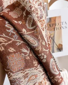 Detailed view of an elegant brown paisley patterned faux cashmere shawl for winter.
