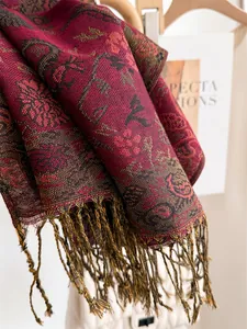 Detailed view of wine red paisley scarf with elegant tassels and soft texture.