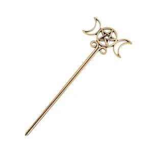 Detailed macro view of a vintage bronze alloy hair stick with moon and pentagram motifs