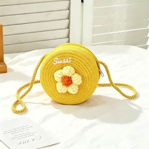 Close-up of yellow round handmade straw bag for girls with flower and Sweet embroidery