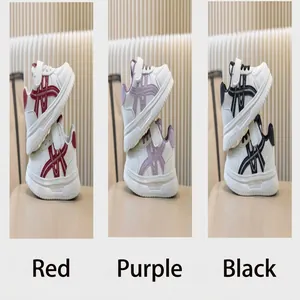 Visualizzazione dettagliata di sneakers bianche per bambini in rosso, viola e nero.