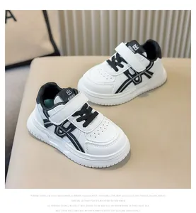 Primo piano di scarpe da ginnastica bianche per bambini con dettagli neri e cinturini velcro