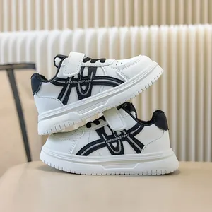Vista laterale ravvicinata di sneaker casual per bambini bianche e nere con velcro