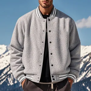 Detailed view of a grey fleece varsity jacket with striped cuffs against snowy mountains