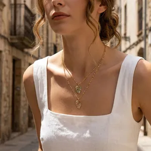 Close-up of double-layered gold leaf necklace with colorful enamel and crystals