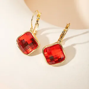 Détail macro de boucles d'oreilles carrées en zircon rouge avec finition or 14K.