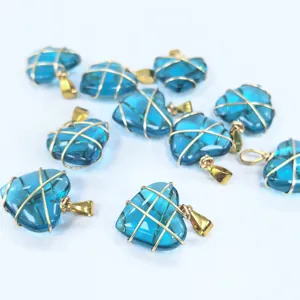 Primer plano de colgantes de corazón de cristal azul con alambre dorado