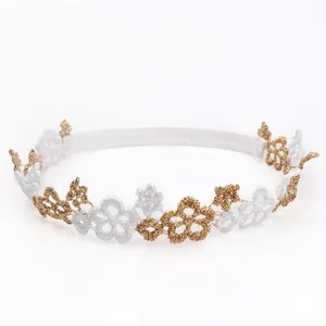 Diadema elástica para bebé con flores de encaje en blanco y dorado detalladas.