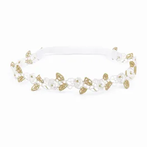Detalle de encaje blanco y dorado con patrón floral en diadema elástica para bebé