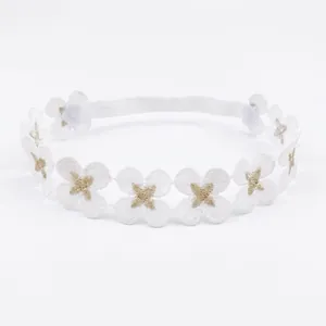 Detalle de diadema de encaje para bebé con flores blancas y bordado de estrella dorada