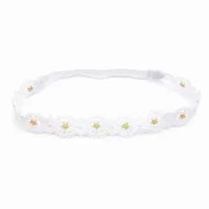 Vista detallada de la diadema de encaje blanco para bebé con flores doradas.