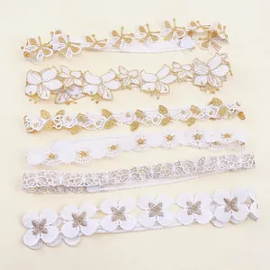 Detalle de seis diademas elásticas para bebé en encaje blanco y dorado con flores