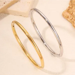 Detailopname van minimalistische gouden en zilveren roestvrijstalen armbanden