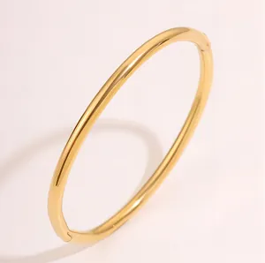 Detailopname van een gladde goudkleurige roestvrijstalen armband met sluiting