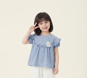 Detail view of a little girl wearing a charming blue gingham ruffle blouse and pants