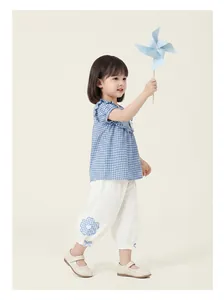 Toddler girl summer outfit with blue gingham doll shirt and white floral pants