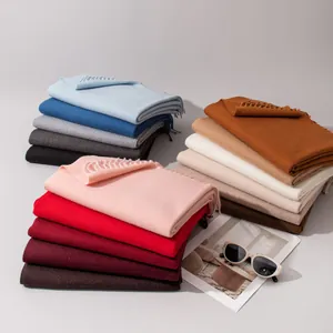 Stapel diverse zachte wollen sjaals in warme winterkleuren met elegante franjes