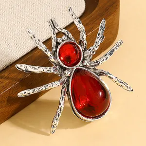 Primo piano di una spilla a ragno in argento vintage con pietre rosse per Halloween