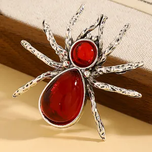 Dettaglio di una spilla a ragno in argento vintage con pietre rosse