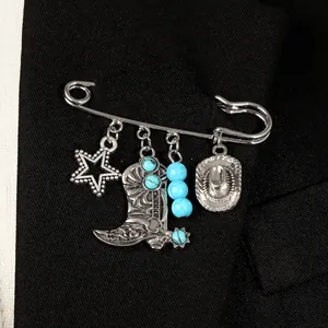 Gros plan sur une broche de cowboy en argent vieilli avec des pendentifs turquoise.