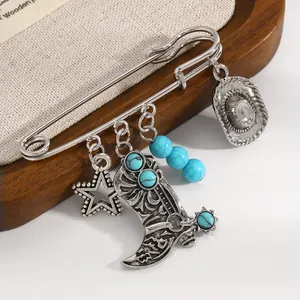 Gros plan d'une broche botte de cow-boy argentée avec perles turquoise et chapeau
