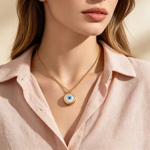 Primo piano di una collana con pendente malocchio dorato e madreperla indossata da modella