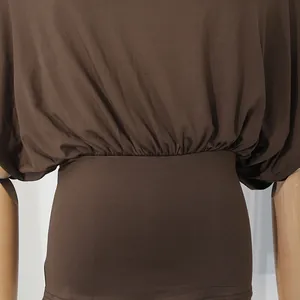 Primo piano della vita arricciata elastica su un top marrone attillato ed elegante.