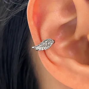 Dettaglio di un orecchino a lobo ad ala d'angelo in argento con zirconi micro-pavé