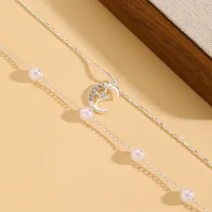 Primo piano di elegante collana d'argento con pendente a stella e luna con perle