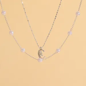 Primo piano dettagliato di un'elegante collana con pendente a luna d'argento con perle