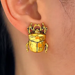 Dettaglio orecchino a scarabeo dorato indossato, gioielli vintage a forma di insetto