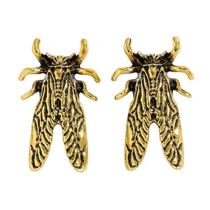 Dettaglio ravvicinato di orecchini a forma di scarabeo dorato retrò