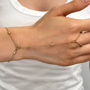 Bracelet de main raffiné en perles dorées avec des détails de breloques goutte d'eau