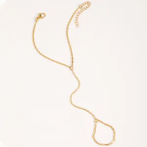 Élégant bracelet de main doré avec bague ajustable au design minimaliste chic.