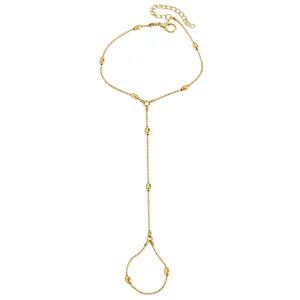 Détail d'une chaîne de main dorée ornée de perles élégantes en forme de gouttes d'eau.