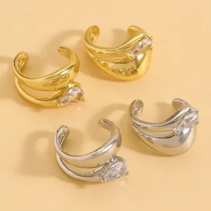 Detail view showing twisted gold and silver finish ear cuffs with teardrop zircons.