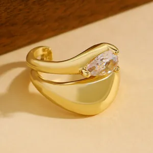 Macro view of gold teardrop zirconia ear cuff with elegant twisted lines detail