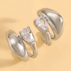 Close-up of elegant silver ear clips with pear-shaped cubic zirconia stones.